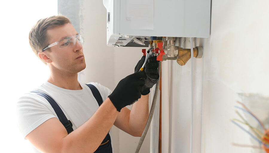 Man with safety glasses is performing a Tankless Water Heater Installation.